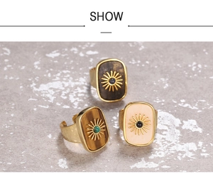 Close-up of adjustable gold rings with tiger eye stone and starburst flower patterns