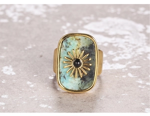 Detailed macro view of rectangular green stone ring with gold sunburst motif