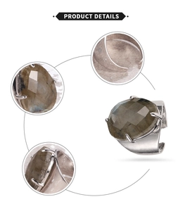 Macro view of adjustable wide band ring with faceted drop-shaped natural gemstone