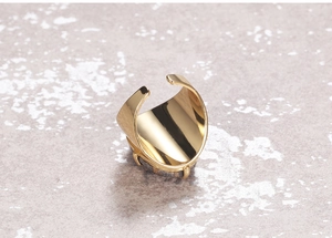 Detail view of golden adjustable wide ring featuring a textured dark grey natural stone inlay