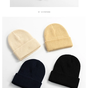 Flat lay of ribbed knit beanies in cream, khaki, navy, and black with folded cuffs