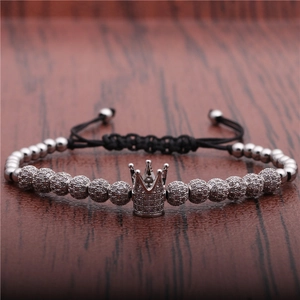 Silver crown braided bracelet with micro-pave zircons and adjustable cord on wood surface