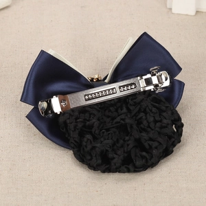 Detail of navy and white ribbon hair bun cover with gold stars on linen background