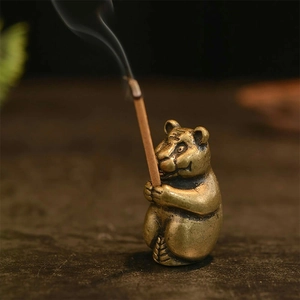 Antique brass tiger incense burner with detailed textures and a burning stick