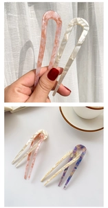Detailed macro view of acetate U-shaped hairpins with elegant marble texture and patterns