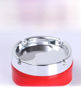 Detail view of the stainless steel ashtray showing four U-shaped cigarette slots and Yin Yang design