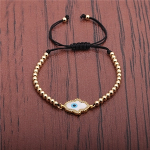 Hamsa Evil Eye bracelet with gold beads and adjustable black cord on wooden background