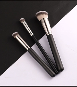 Three professional foundation and concealer brushes with black handles and bicolor bristles