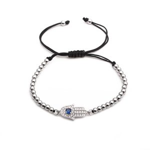 Detailed view of silver Hamsa Hand charm with blue zircon on adjustable black woven cord