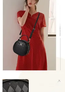 Detail of black quilted crossbody bag with golden hardware and adjustable strap