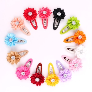 Flat lay of colorful fabric floral BB hair clips with rhinestones in 14 vibrant colors