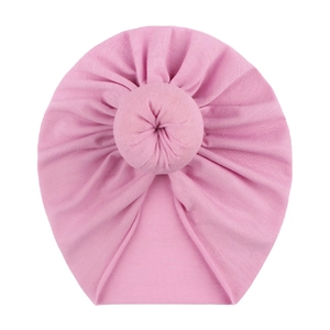 Soft pink baby turban hat with a cute donut knot design made of breathable cotton fabric