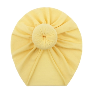 Cute yellow newborn turban hat with donut knot decoration on a plain white background
