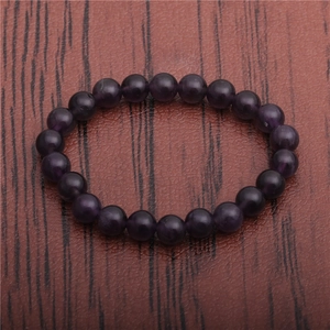 Macro view of 8mm purple natural stone beads on a textured dark leather background