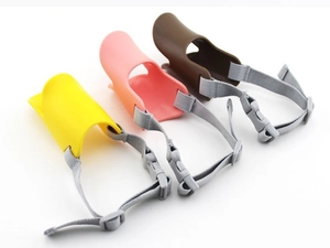 Three duck-bill dog muzzles in yellow, pink and brown colors with adjustable nylon straps