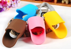 Detail of colorful silicone duck-bill dog muzzles with adjustable nylon straps on wood
