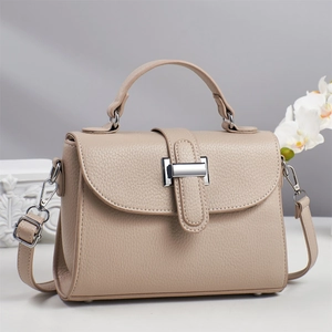 Elegant beige lychee texture leather handbag with adjustable strap and silver metal buckle