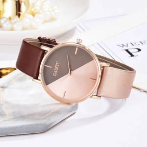 Detail shot of a dual-tone ladies quartz watch with brown leather strap on marble