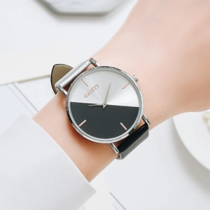 Detail shot of a two-tone minimalist quartz watch with black leather strap on the wrist