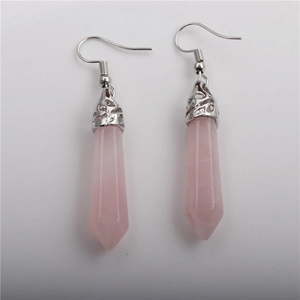 Detailed view of pink hexagonal crystal drop earrings with silver ornate metal hooks