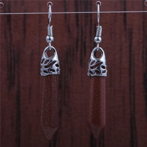 Detail of red sandstone hexagonal prism earrings with silver hollow flower pattern hooks