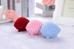 Three elegant shell-shaped velvet jewelry boxes in red, pink, and blue for rings and studs