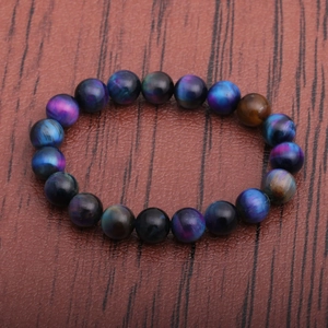 Starry tiger eye stone bracelet with blue and purple beads on a wooden background