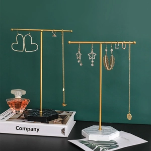 Golden T-bar jewelry stands with marble base for displaying earrings and necklaces