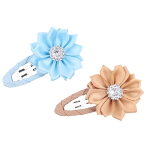 Detail of floral ribbon hair clips with rhinestone centers in blue and champagne