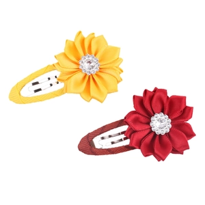 Detailed shot of yellow and red ribbon flower hair clips with rhinestones and metal BB clips