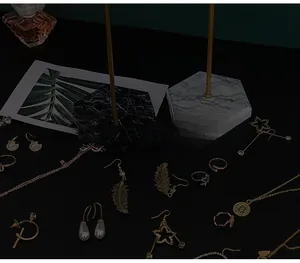 Detail von goldenem Schmuck auf einem sechseckigen Marmorsockel-Schmuckständer