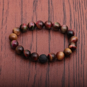 Beaded men's bracelet with tiger eye and lava stone on a brown wooden texture