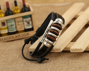 Detail of vintage multi-layer braided leather bracelet with silver beads and wood accents