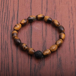 Handmade tiger eye bead bracelet with black volcanic stone on dark wood background