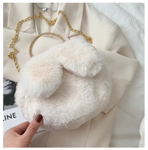 Detail of white faux fur rabbit bag with gold metal rings and a fine chain strap