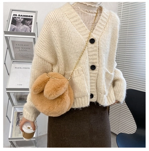 Detailed view of light brown plush rabbit bag with golden chain and cute long ears