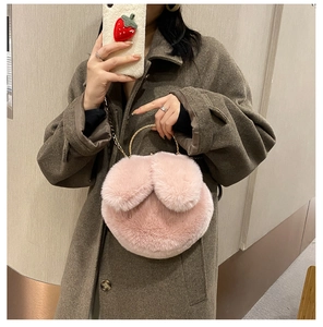 Detailed view of the pink faux fur handbag featuring cute rabbit ears and gold chain strap