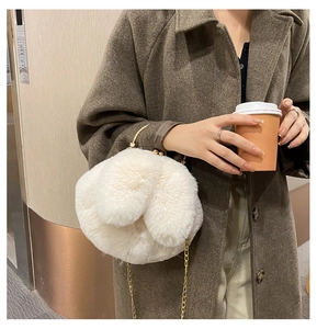 Detail of cream white plush bunny bag with soft faux fur texture and gold chain strap