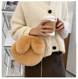 Close-up of plush rabbit ear crossbody bag in khaki with a golden metal chain strap