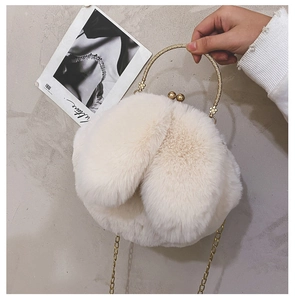 Detail of white plush handbag with cute rabbit ears and floral gold metal handle