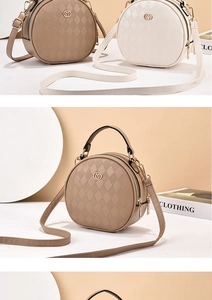 Close-up of quilted round crossbody bag with golden hardware and dual zipper details