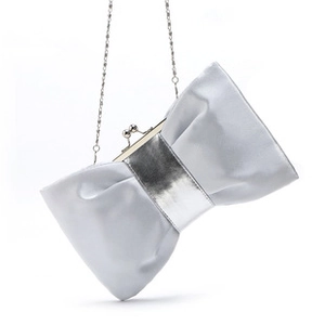 Detail of silver satin bow evening clutch bag with metal strap and buckle closure