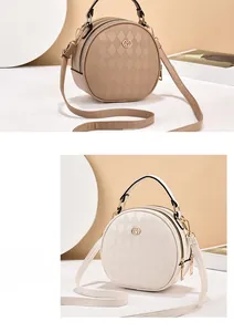 Detailed macro view of beige PU leather round bag with diamond quilted texture and M logo