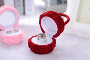 Macro shot of rose-shaped velvet ring box in red and pink with soft flocking detail