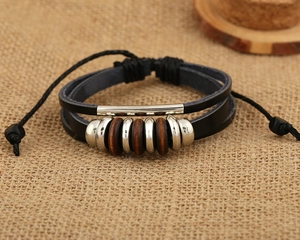 Detail of multilayer vintage leather bracelet featuring metallic beads and adjustable cord
