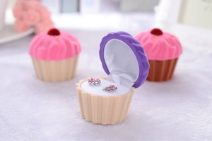 Detail of a cupcake-shaped velvet jewelry box in beige and pink with crystal earrings