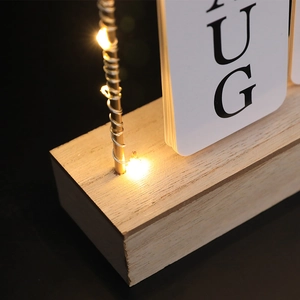Minimalist wooden desk calendar with LED light string and white flip cards for home decor