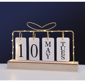 Detail of creative desk calendar featuring gold frame, LED lights, and wooden base