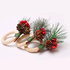 Set of three Christmas napkin rings with pine needles, cones and red berries on wooden loop