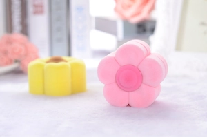 Macro shot of flower-shaped velvet jewelry boxes in soft pink and yellow tones